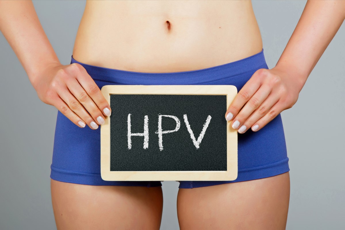 Γυναίκα που κρατάει μια πινακίδα που λέει HPV